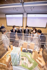 Opening Ceremony - Participants discussing near a campus model