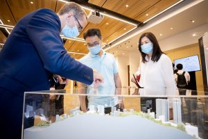 Opening Ceremony - participants looking at model of the future Pokfield Campus